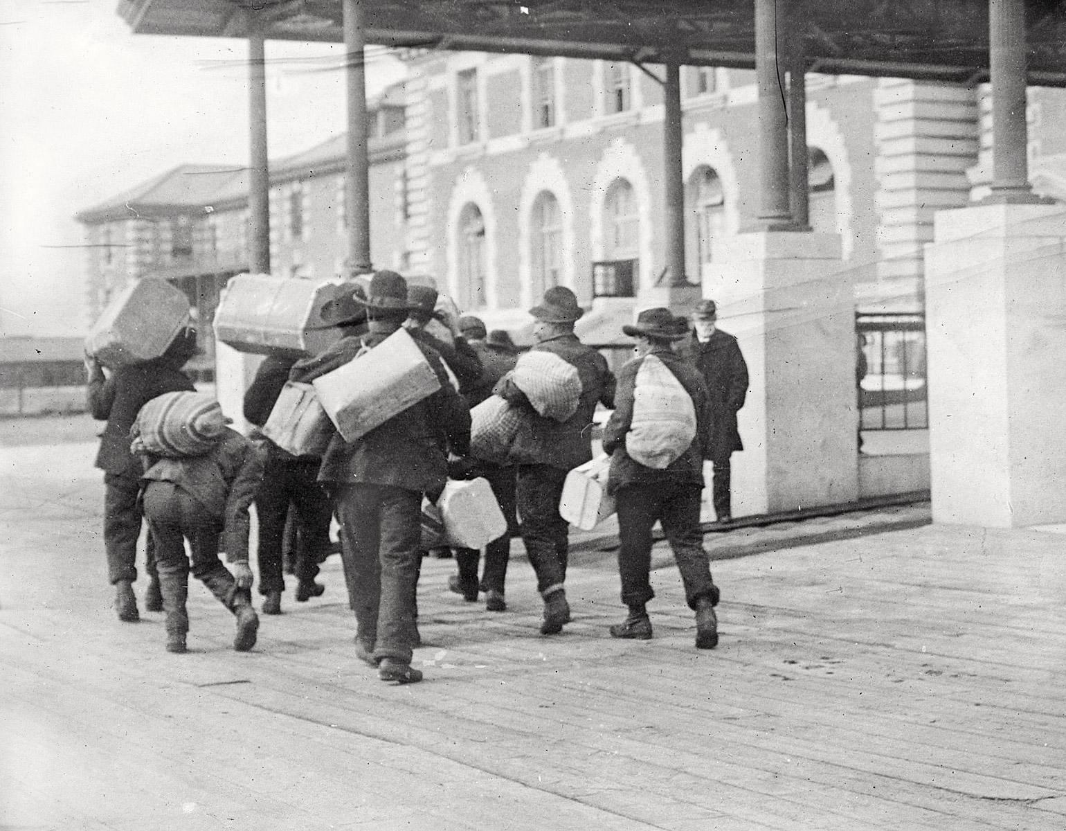 Emigranter med väskor vid Ellis Island.